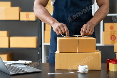 Preview: Office workers or self-employed business people use a string to tie parcel boxes for delivery to cus
