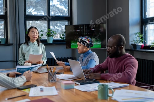 Preview: Young confident business coach standing by table in front of audience