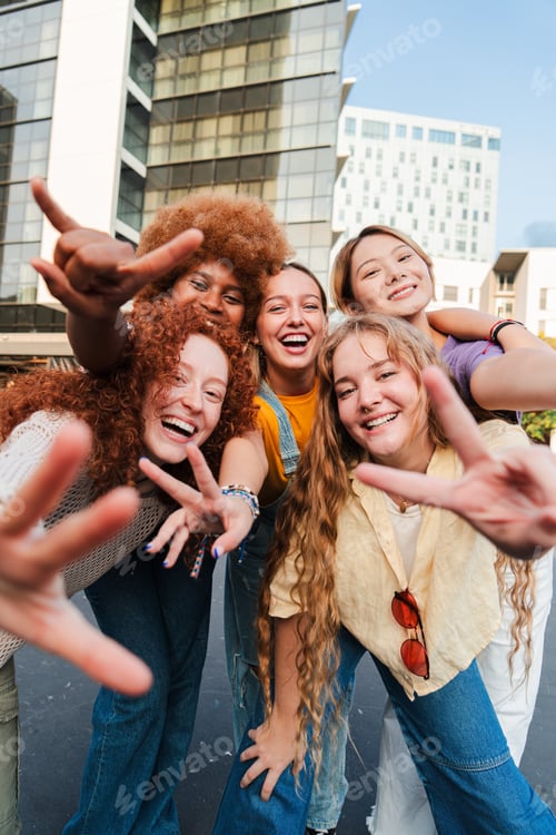 Preview: Vertical. Group of only girls, gesturing with hands and looking at camera. Five young women smiling
