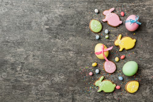 Preview: holiday preparation Multi colors Easter eggs with cookies on colored background .