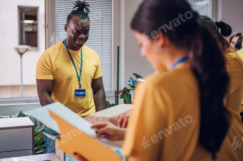 Preview: Group of multiracial volunteers working in community charity donation center