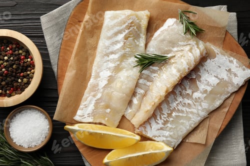 Preview: Fresh raw cod fillets, spices and lemon on wooden table, flat lay