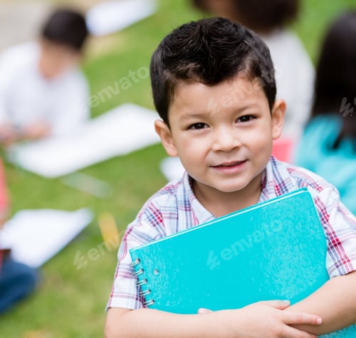Preview: Happy Boy At The School Holding A Notebook And Smiling