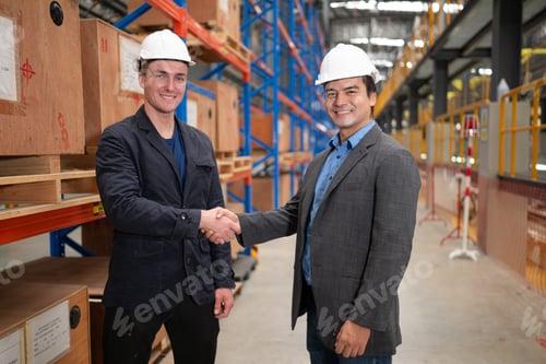 Preview: Two businessmen shaking hands in a warehouse It is a warehouse of spare parts and equipment