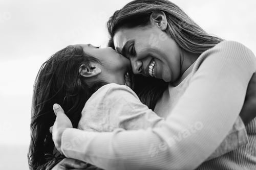 Preview: Happy latin mother and daughter having tender moment together outdoor - Main focus on mom mouth