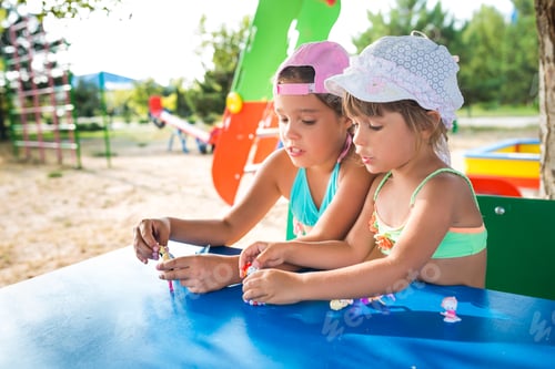 Preview: Two little cute girls playing dolls outdoors
