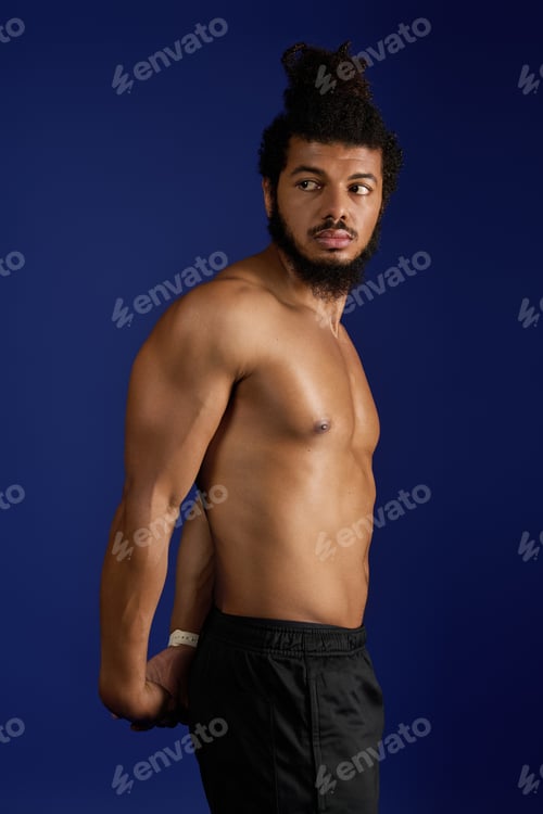 Preview: Athletic African American man shows strength while working out on blue background