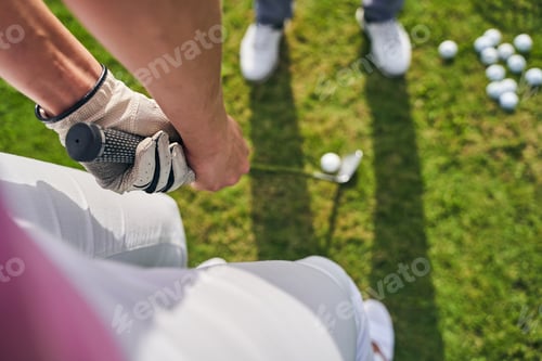 Preview: Sportswoman holding a golf putter with both hands