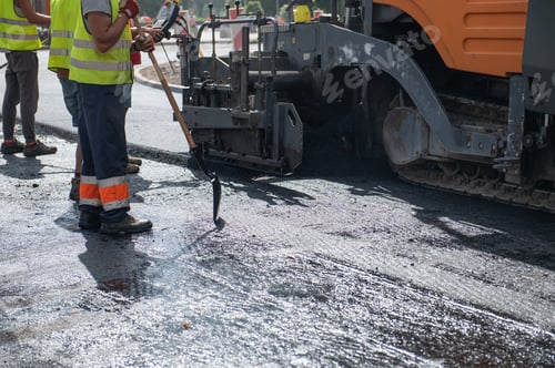 Preview: Workers operating asphalt paver machine during road construction and repairing works