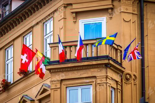 Preview: View of balcony of old brown building with flags