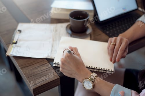 Preview: Close up. Business woman taking notes in notebook on desk at office.