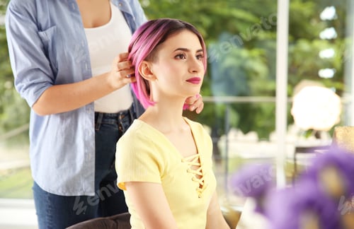 Preview: Professional hairdresser working with young woman in beauty salon. Trendy hair color