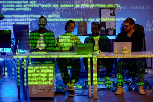 Preview: Row of four young diversity programmers sitting by desk in front of laptops