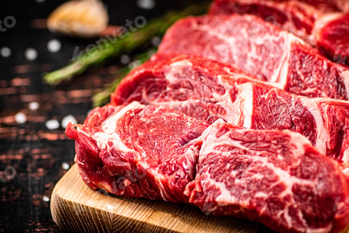 Preview: Raw beef on a wooden cutting board with rosemary.