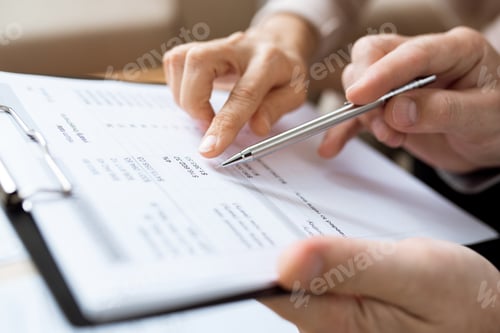 Preview: One of humans holding pen over paper while discussing financial expenses