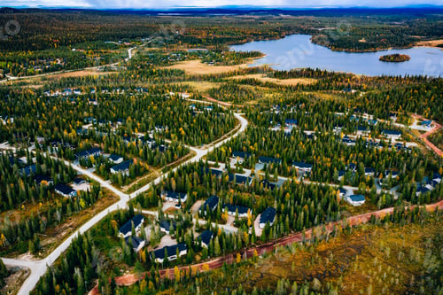 Preview: Aerial view of cottage village with colorful trees in autumn season forest in rural Finland.