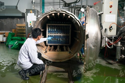 Preview: worker working in drink factory at conveyor belt with fruit juice glass bottled in production line