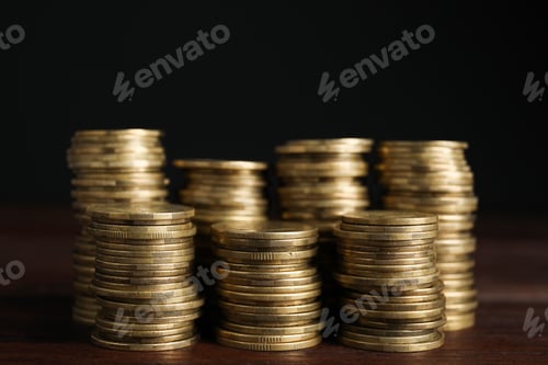 Preview: Stacks of Golden Coins on Wood Surface