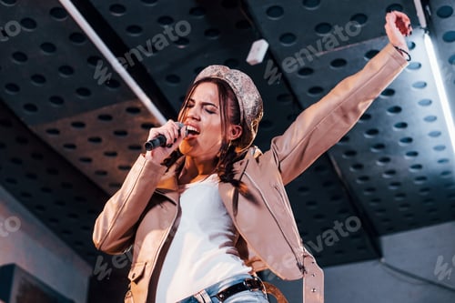 Preview: Young beautiful female performer rehearsing in a recording studio