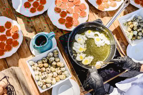Preview: Fresh quail eggs fried in oil in a showcooking