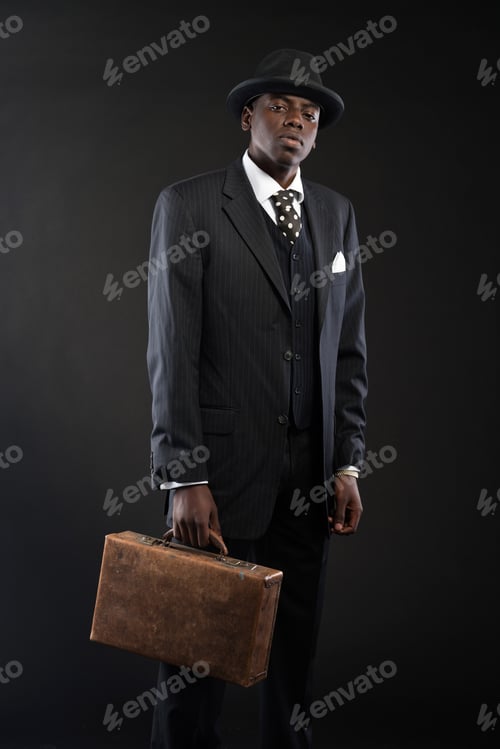 Preview: Retro African American Businessman Wearing Striped Suit And Tie And Black Hat. Holding Suitcase