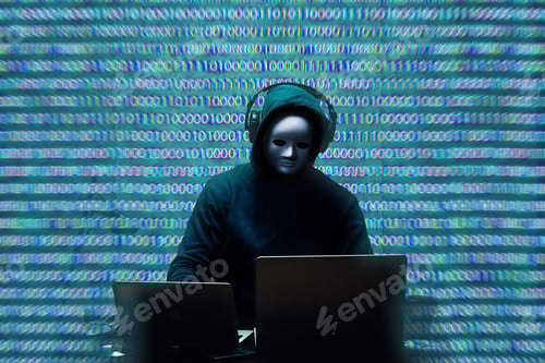 Preview: Anonymous hacker wearing face mask working on computer in dark room