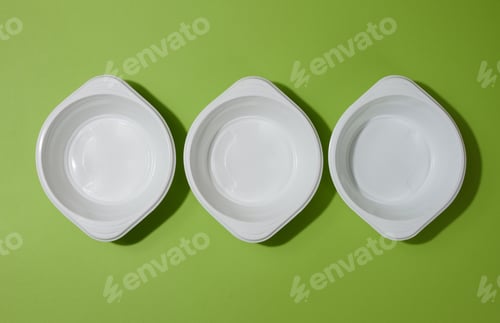 Preview: White empty plastic soup bowl on green background, top view