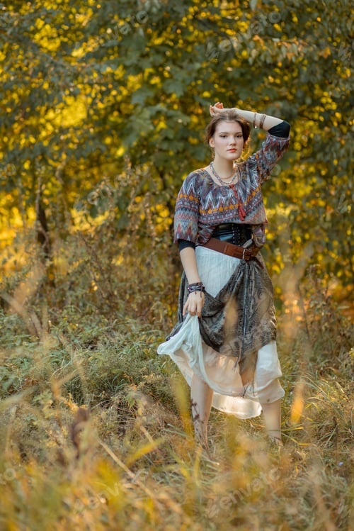 Preview: Young woman in boho style clothes posing in autumn forest