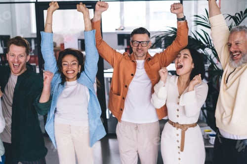Preview: Group of cheerful multiracial colleagues with raised hands in office