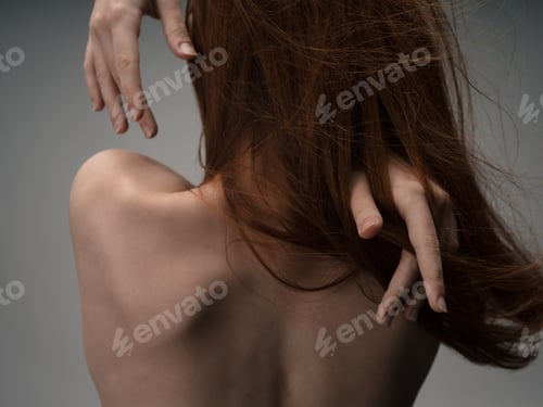 Preview: Back view of sexy red-haired woman naked back touching with hands
