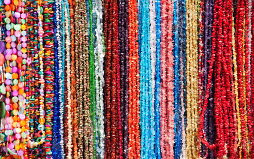 Preview: Closeup of colorful stone necklaces under the sunlight - fashion concept