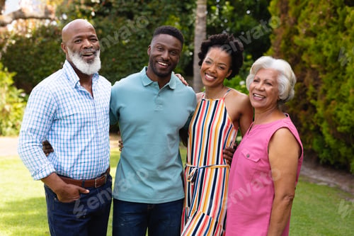 Preview: Portrait of happy african american family standing together at backyard garden