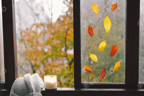 Preview: Still life details in home on a wooden window. Sweater, candle, hot tea and autumn decor