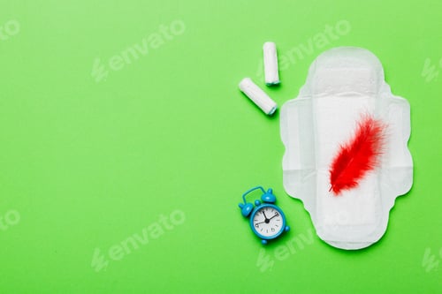 Preview: Ringing alarm clock with sanitary female tampons and menstrual sanitary pads.