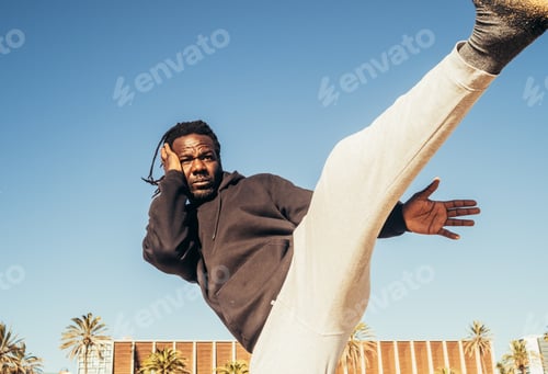 Preview: Young African-American male practicing kicks on a beach