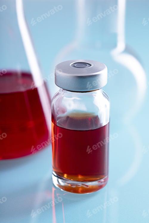 Preview: Vertical closeup shot of a vial of red liquid in a lab