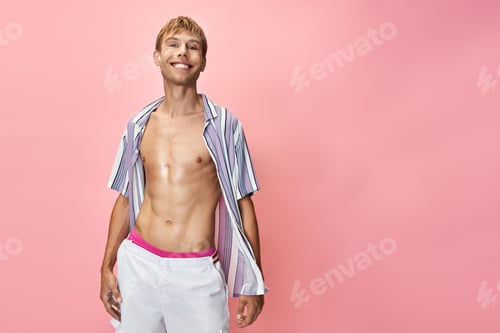 Preview: Vibrant queer fashion shoot featuring a confident model against a playful pink backdrop