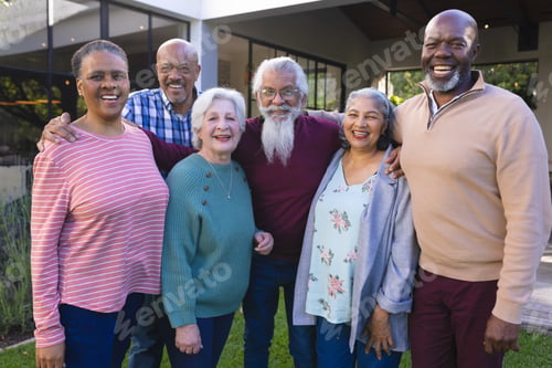Preview: Happy diverse group of senior friends walking next to house in sunny garden