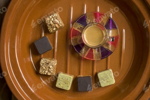 Vorschau: Luftaufnahme verschiedener Arten von quadratischen Süßigkeiten mit Tee auf einem Holztablett