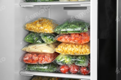 Preview: Plastic bags with different frozen vegetables in refrigerator