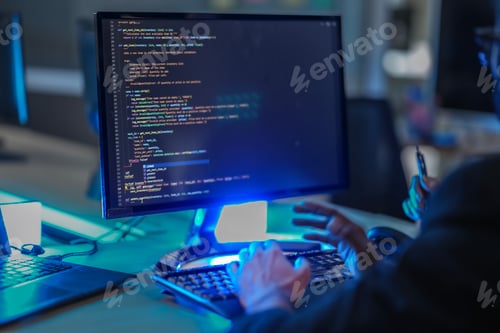 Preview: backend AI developer programs a complex algorithm late at night in a data center.