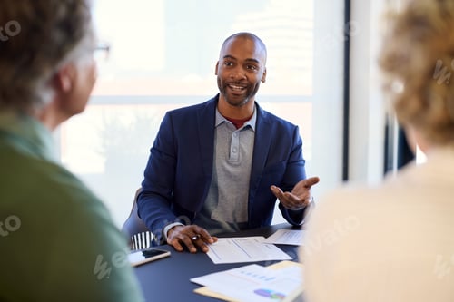 Preview: Confident black businessman advising mature couple on finance