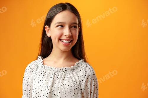 Preview: Photo of teen girl smiling portrait against yellow background in studio