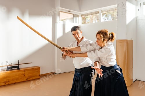 Preview: Martial Artist Demonstrating Bokken Defense Technique in Bright Dojo