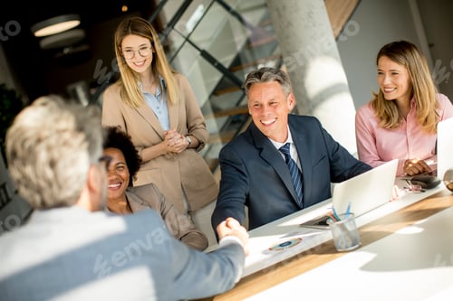 Preview: Business people shaking hands by the desk in the office