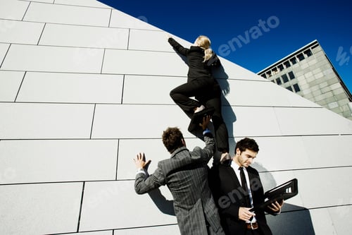 Preview: 2 men helping woman over wall