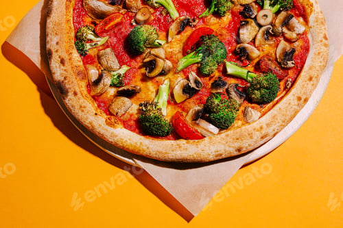 Preview: Delicious vegetable pizza topped with mushrooms, tomatoes, and broccoli on a vibrant yellow