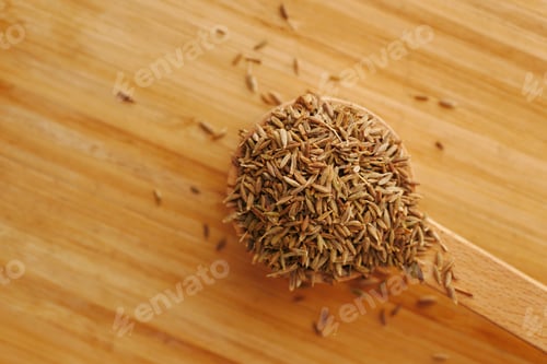 Preview: cumin seeds on spoon on table , close up