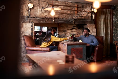 Preview: Couple Making Toast As They Meet For Lunchtime Drinks In Traditional English Pub