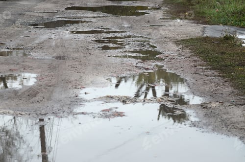 Preview: Photo of a fragment of a destroyed road with large puddles in rainy weather